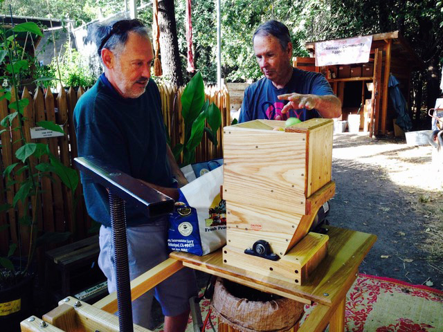 Two men using the apple press